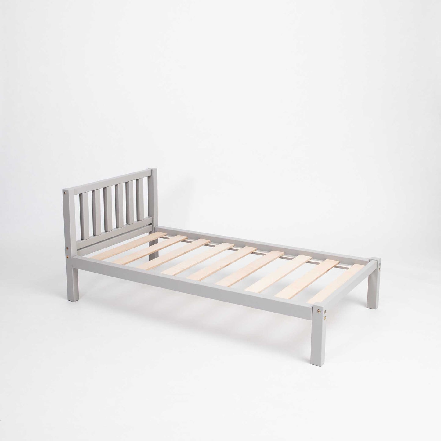A Sweet Home From Wood 2-in-1 toddler bed on legs with a vertical rail headboard, with wooden slats.