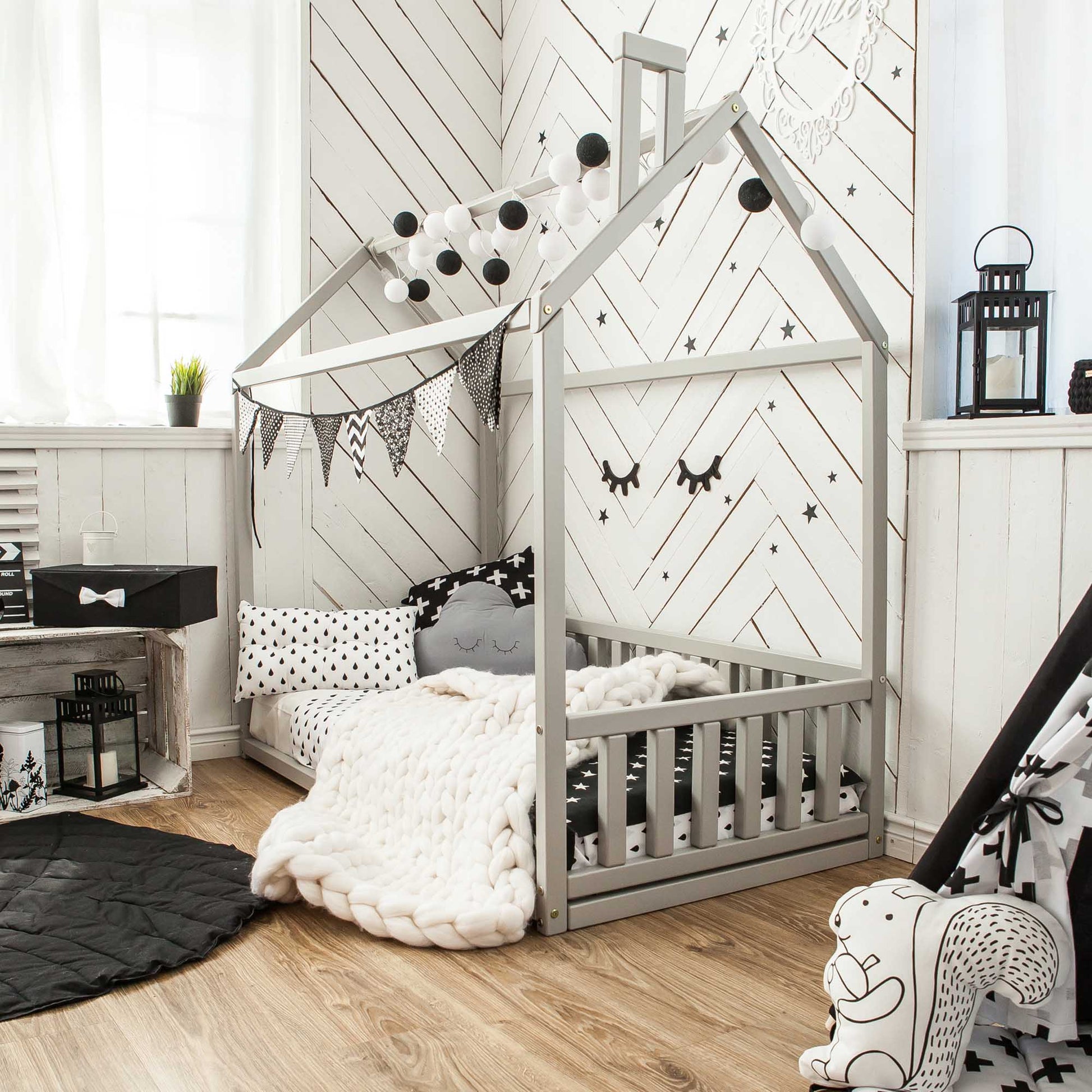 A cozy sleep haven with a Sweet Home From Wood Kids' house-frame bed with 3-sided rails.