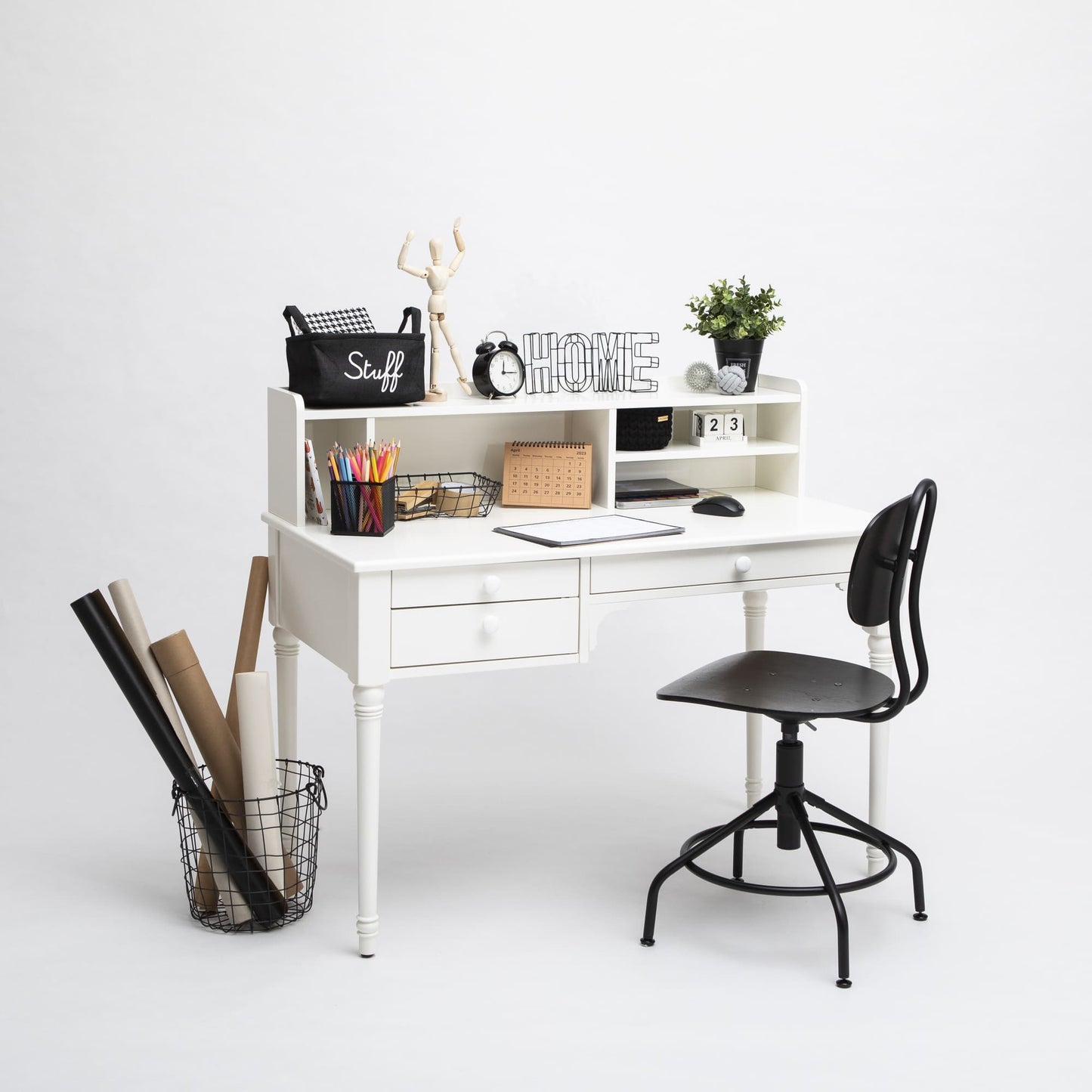 A well-organized white Table with a hutch, Pedestal desk with shelves, a laptop, decorative items, and a black chair against a plain background.