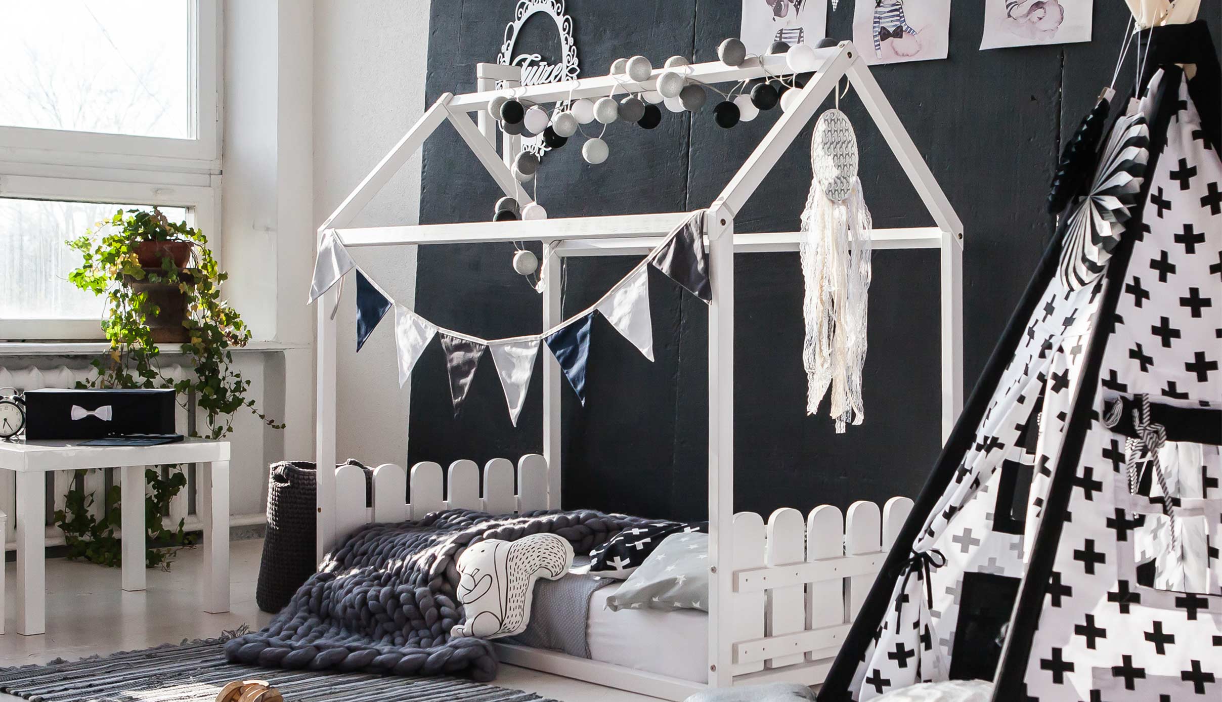 A black and white bedroom with a teepee bed.