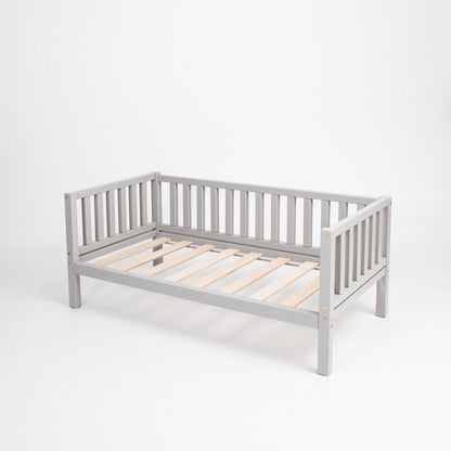 A grey Sweet Home From Wood Montessori-inspired daybed with wooden slats on a white background.