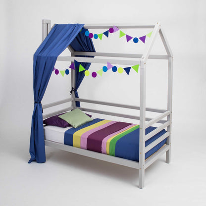 A Children's house bed on legs with 3-sided rails with a canopy and curtains.