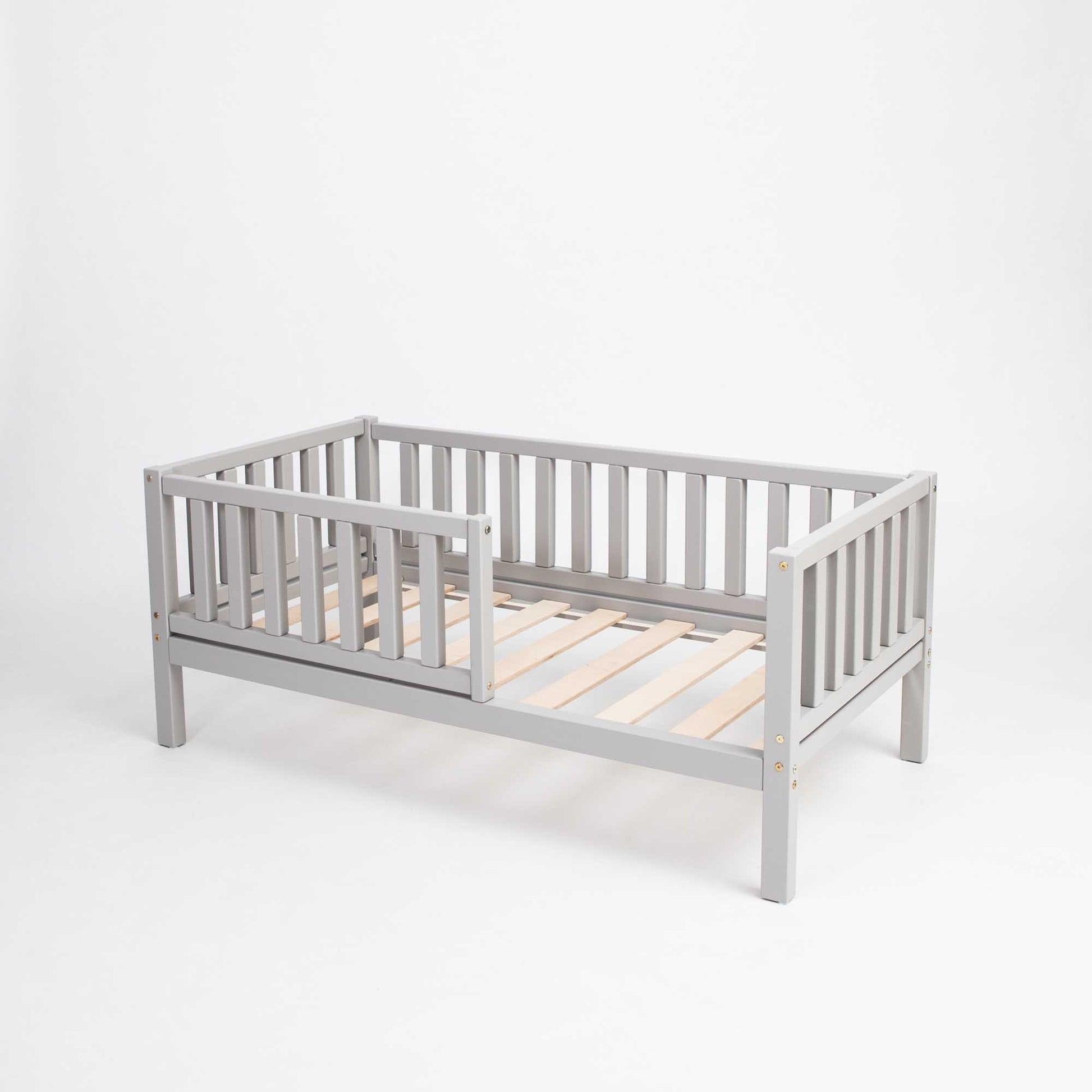 A Sweet Home From Wood toddler bed on legs with a fence, perfect for independent sleeping.