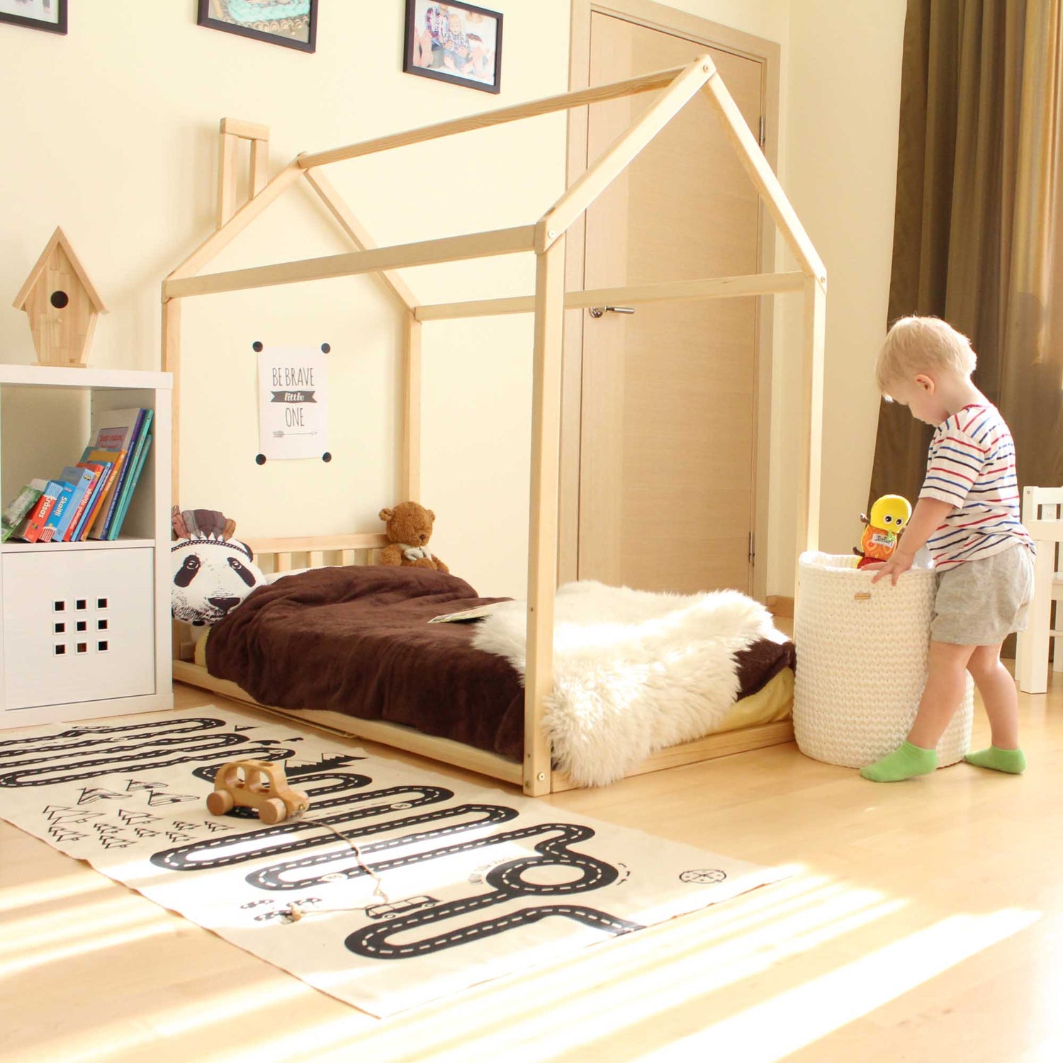 A Sweet Home From Wood house-frame bed with a headboard in a child's room.