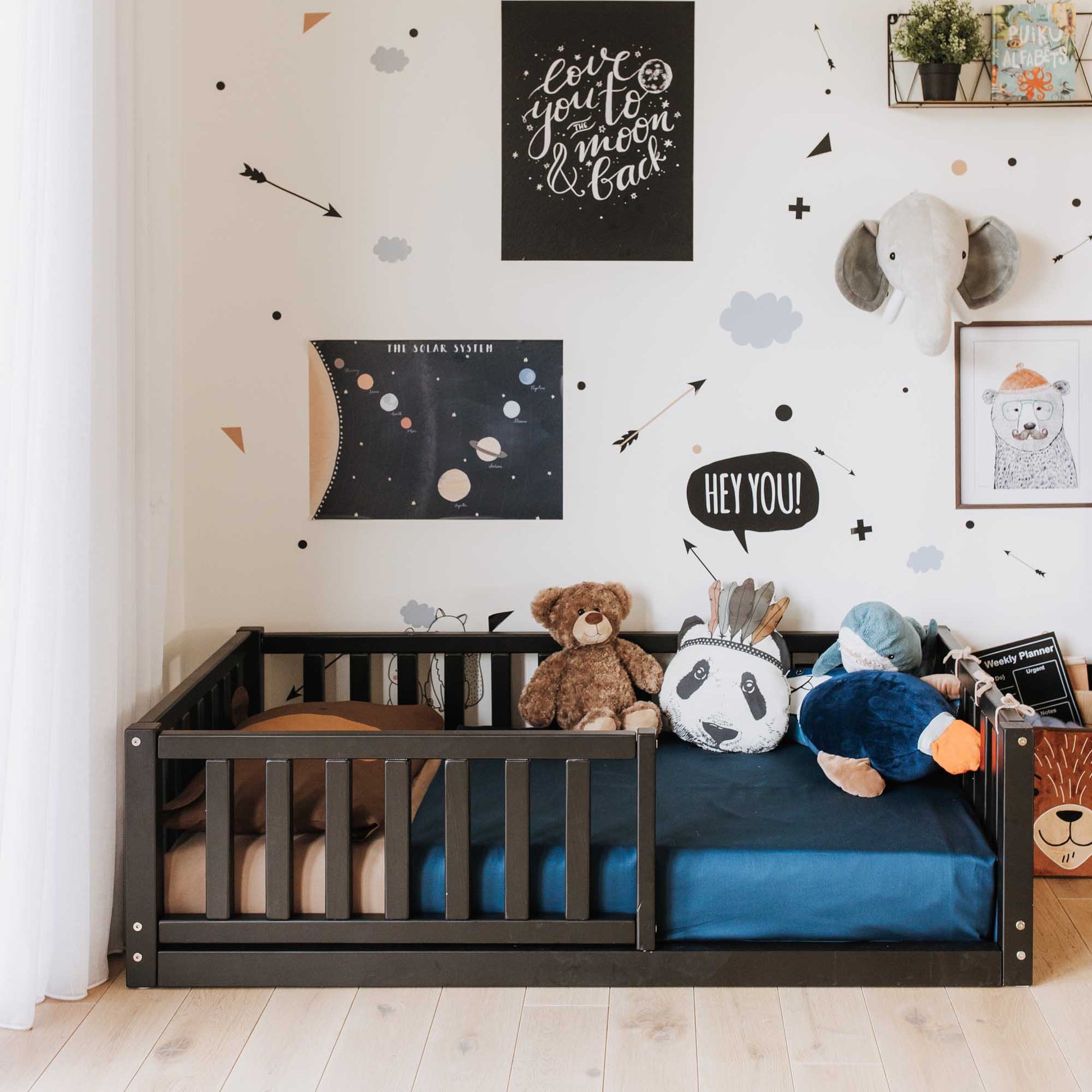 A child's room with long-lasting Sweet Home From Wood stuffed animals and a solid pine 2-in-1 toddler bed on legs with a vertical rail fence.