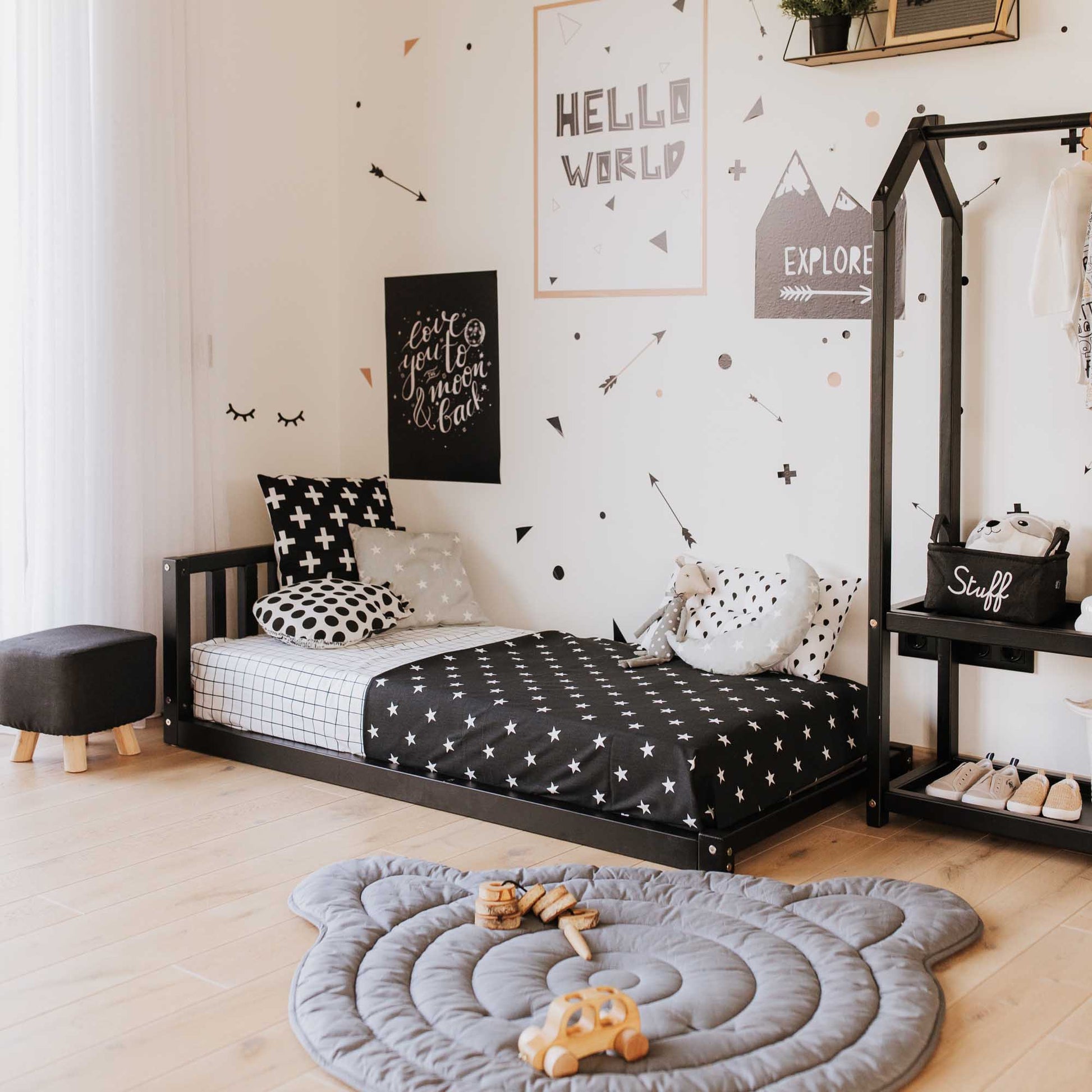 A black and white children's room with polka dots featuring a Sweet Home From Wood toddler bed with a headboard for boys.