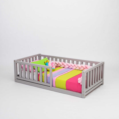 A Sweet Home From Wood 2-in-1 toddler bed on legs with a vertical rail fence, featuring a colorful striped blanket, made from solid pine for durability.