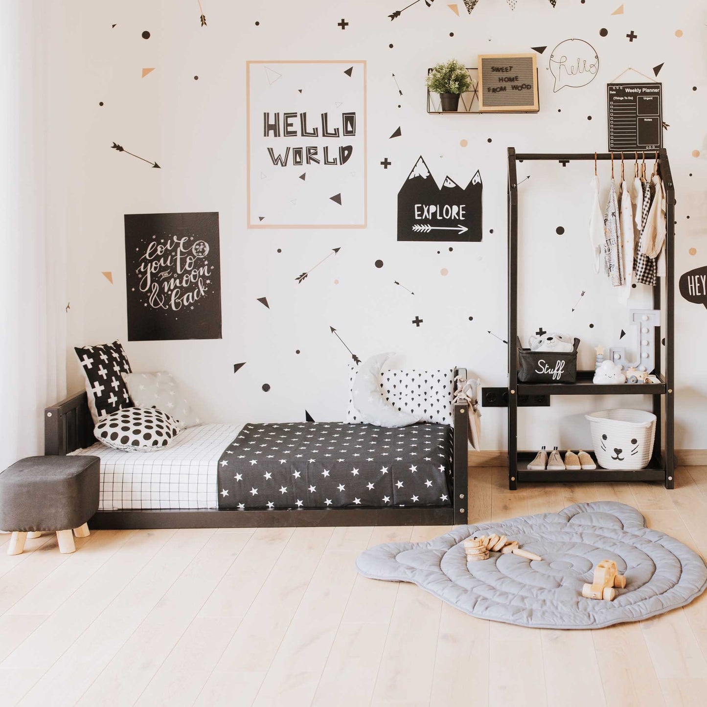 A black and white children's room with polka dots on the wall, featuring a Sweet Home From Wood kids' bed with a headboard and footboard.