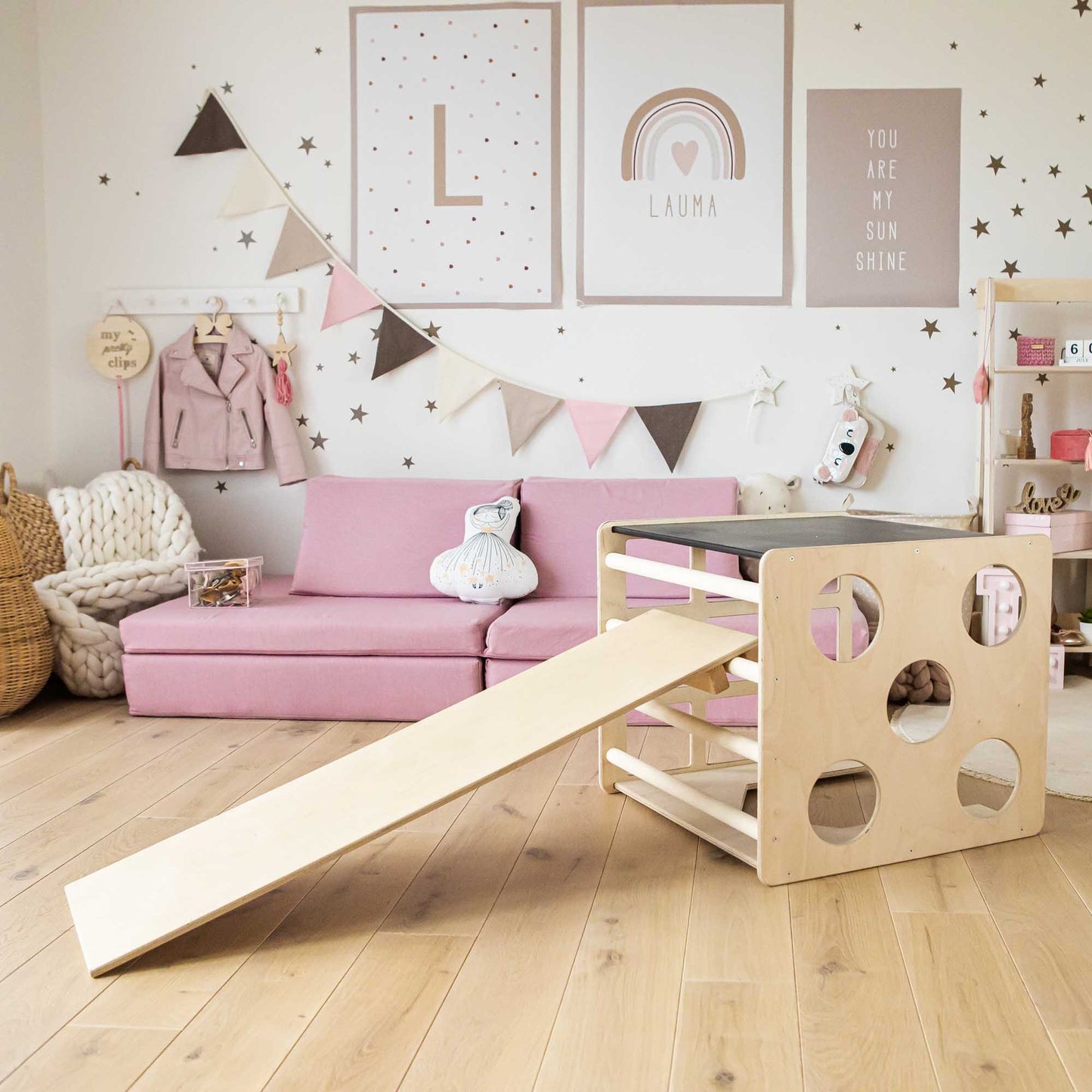 A children's room with a Sweet Home From Wood activity cube with sensory panels and a ramp and an indoor climber.