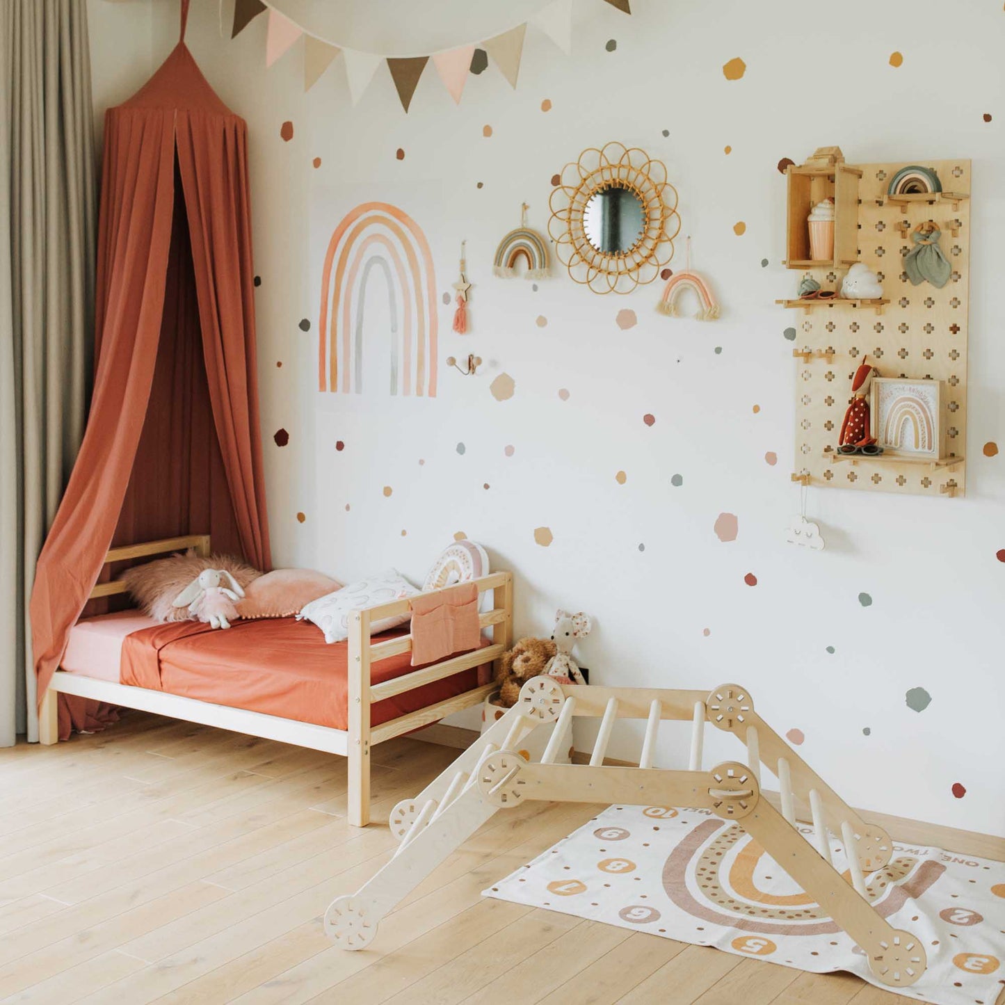 A child's room with a Sweet Home From Wood kids' bed on legs with a horizontal rail headboard and footboard and a canopy.