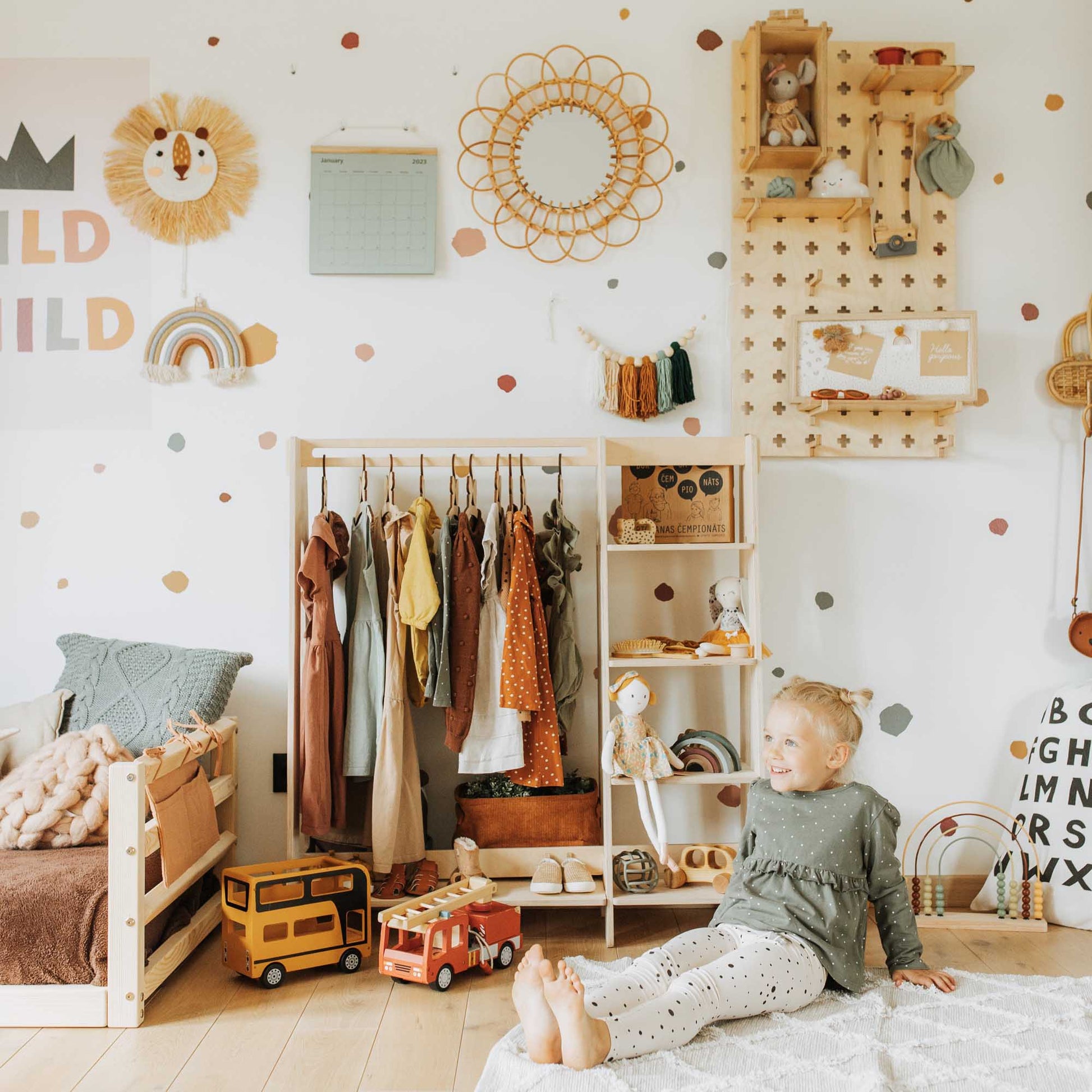 A child's room filled with toys, stuffed animals, and a Sweet Home From Wood Montessori wardrobe.