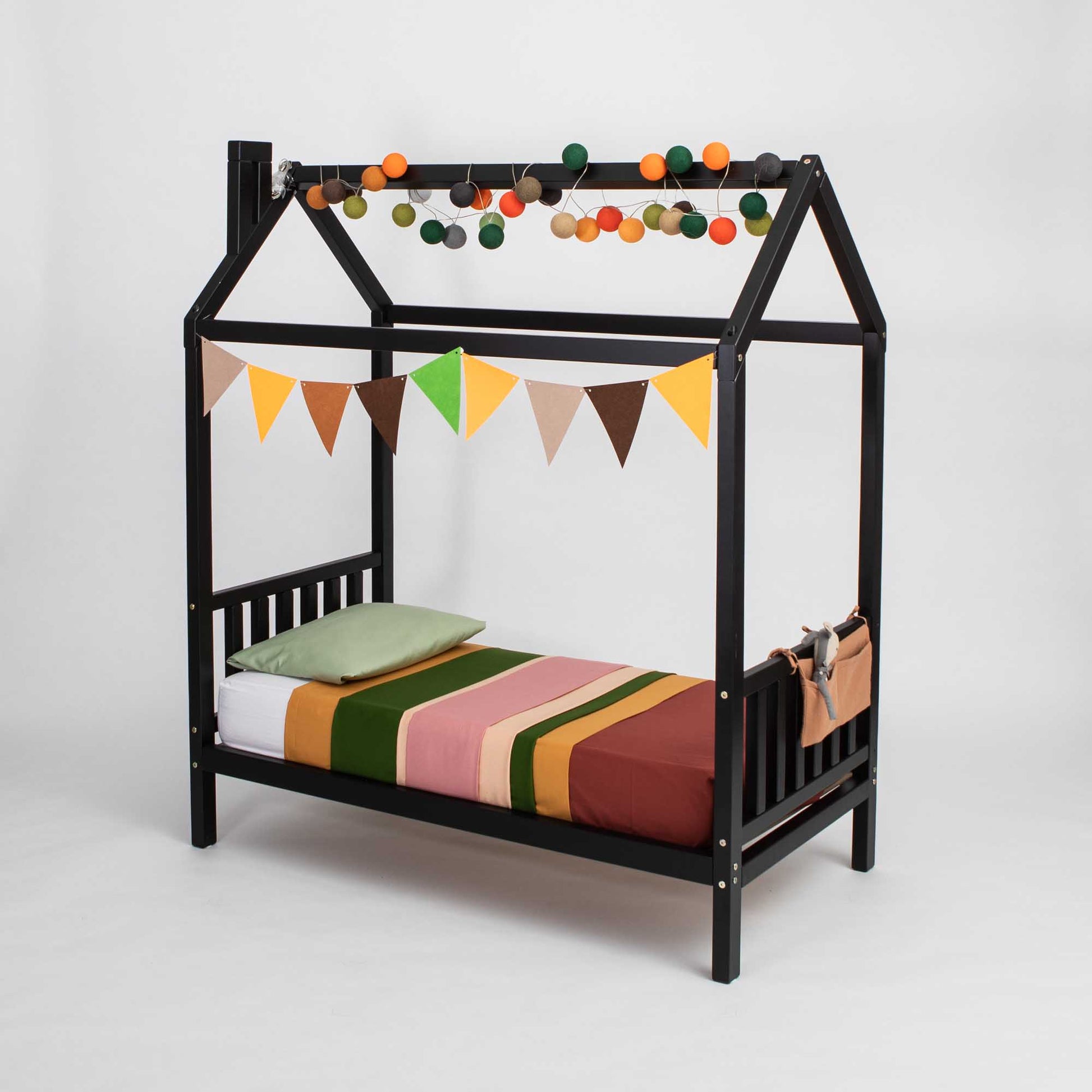 A toddler house bed on legs with a headboard and footboard with a raised house bed and canopy.