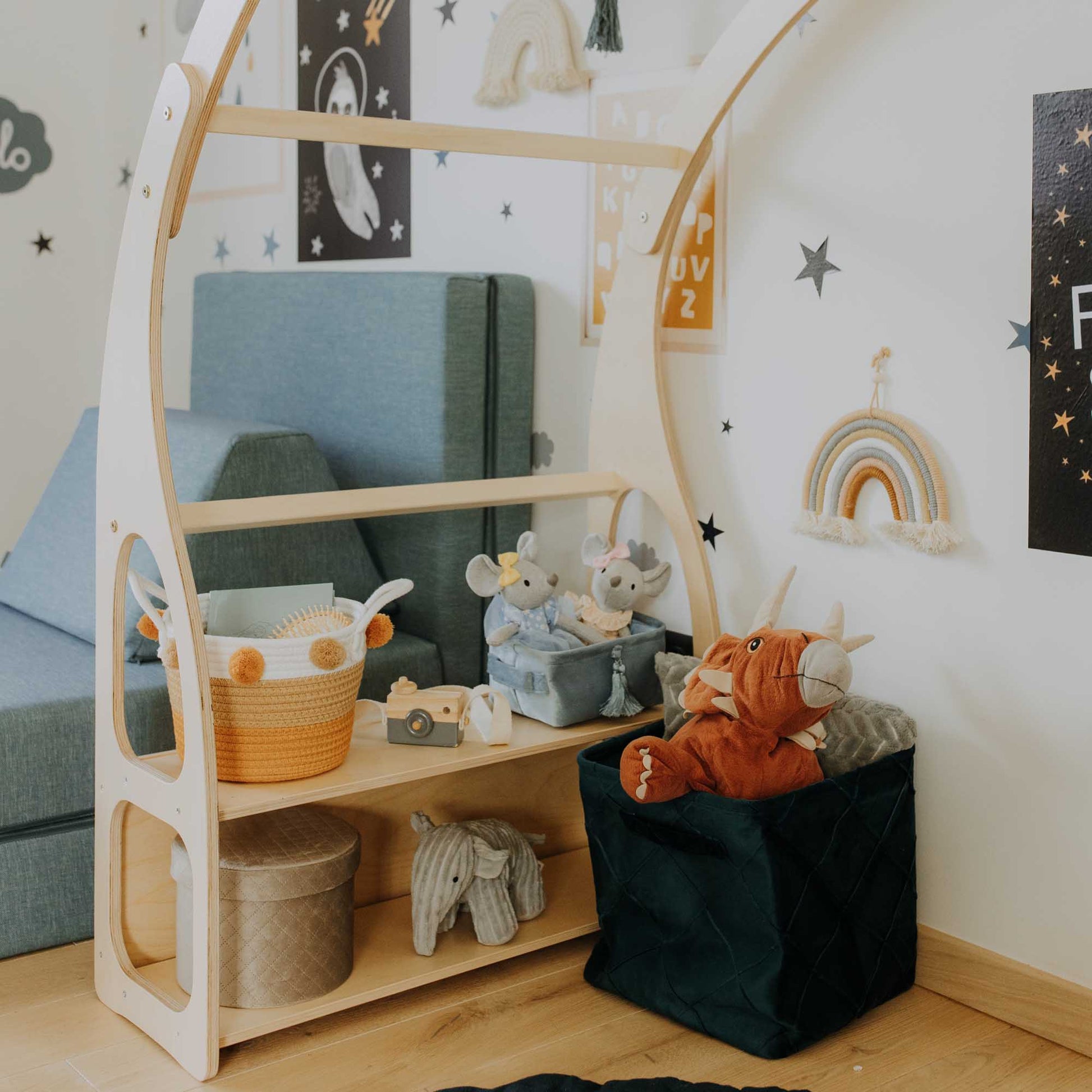 A child's room with a bed, Sweet Home From Wood Montessori toy shelf, and toys.