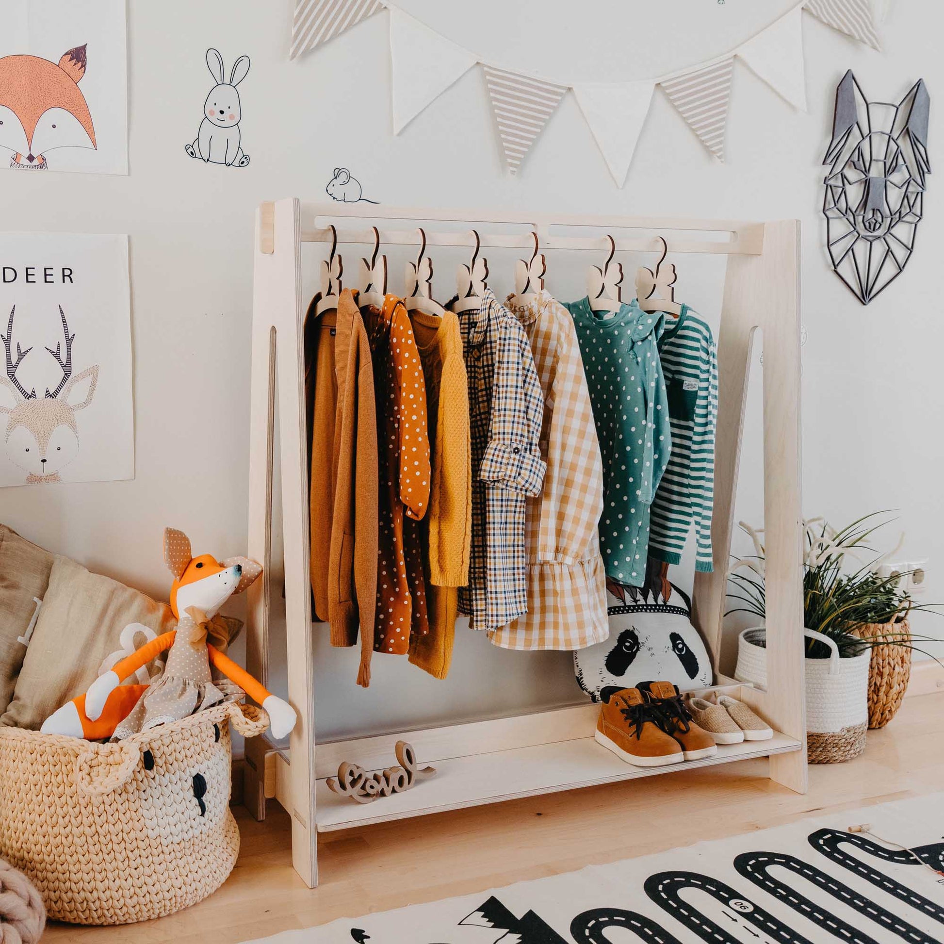 A child's room with Sweet Home From Wood Kids' clothing rack hanging on an open wardrobe.