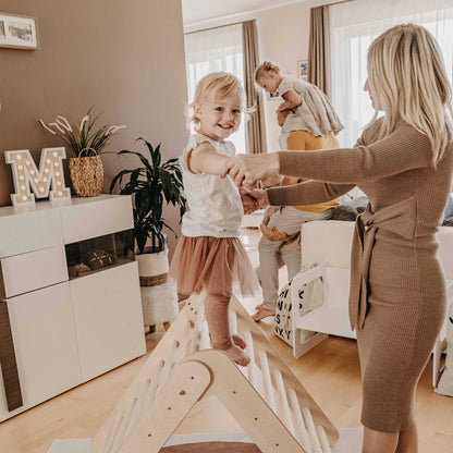 A woman and her daughter engaging in motor skills development on a Foldable climbing triangle with 2 slope levels play structure in their living room.