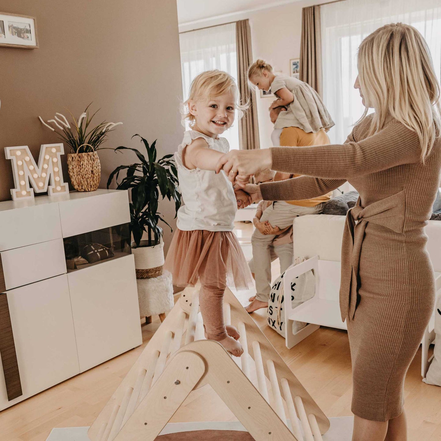 A mother and her daughter enjoying an eco-friendly Climbing Triangle + Foldable Climbing Triangle + a Ramp in their living room.
