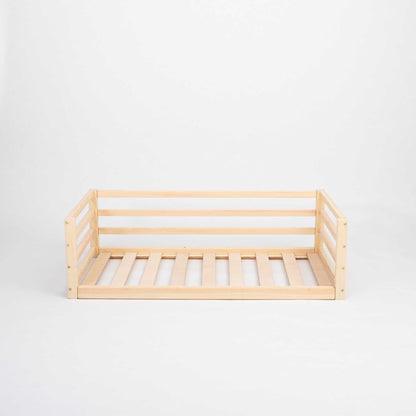 A Sweet Home From Wood transitional children's bed with wooden slats and a safety rail.