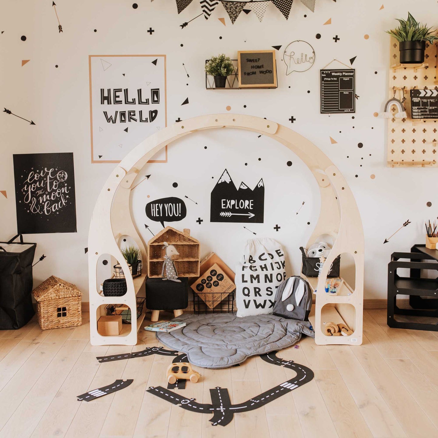 A child's playroom with a Sweet Home From Wood wooden arch and Montessori toy shelf.