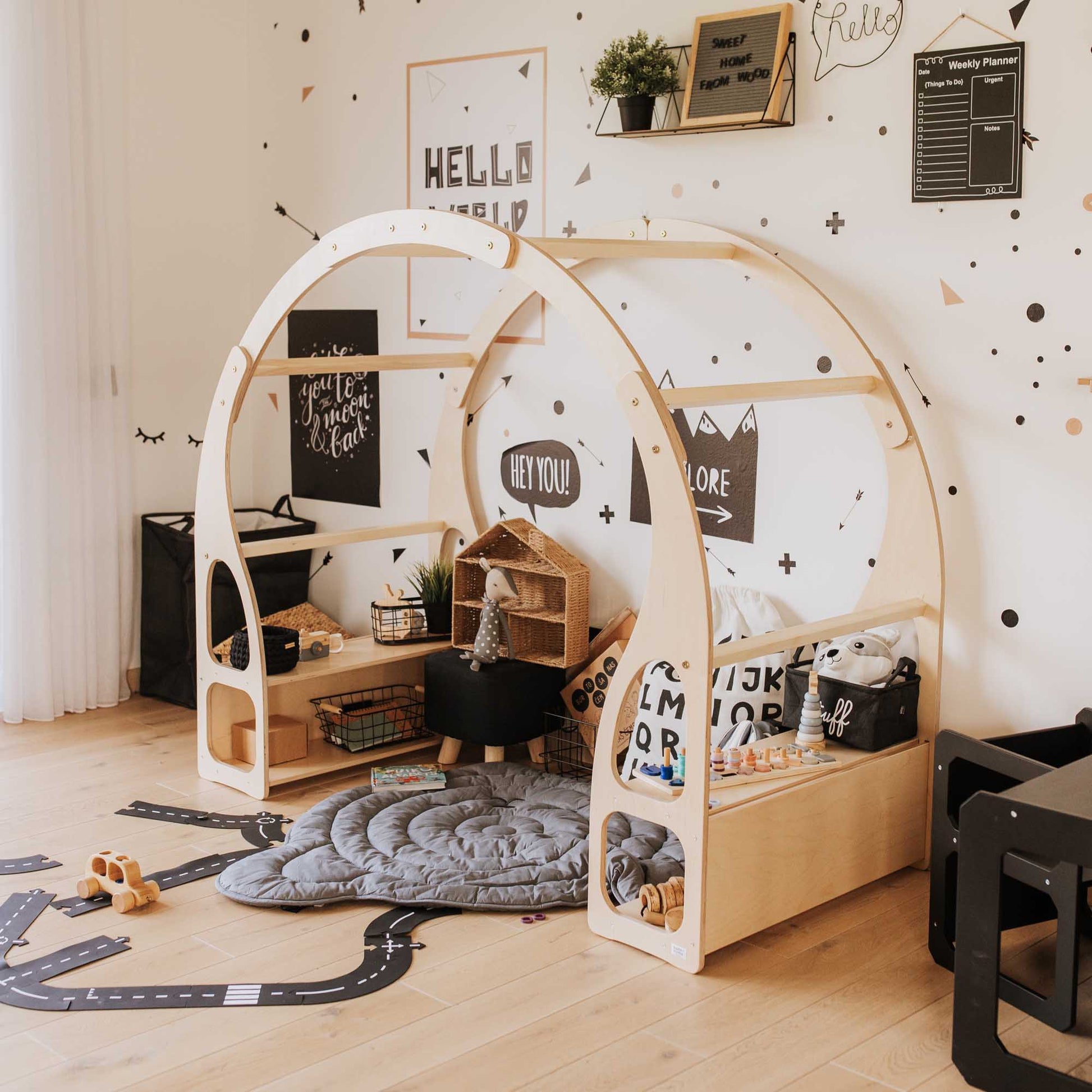A children's room with a Sweet Home From Wood wooden play stand for toddlers and black and white polka dots, featuring an open toy storage shelf.