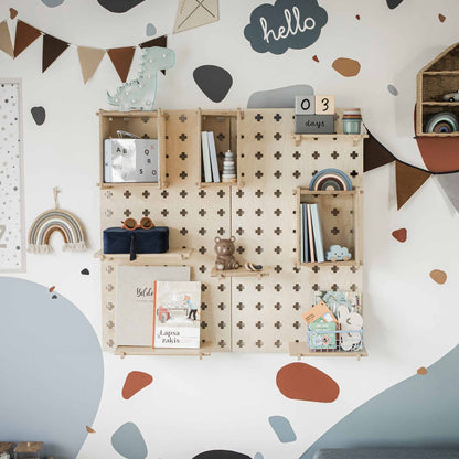 A children's room wall featuring a Large Pegboard Floating Display Shelf adorned with books, toys, and decorations, including a 'hello' sign and a '03 days' countdown display. The organized space is complemented by playful, colorful designs, making it an ideal storage solution for your little one's treasures.