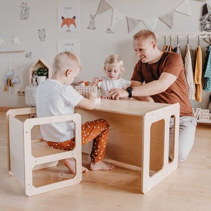 A man and two children playing at a Sweet Home From Wood Montessori weaning table and 2 chair set.