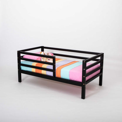 A Sweet Home From Wood Kids' bed on legs with a horizontal rail fence and a colorful striped sheet.